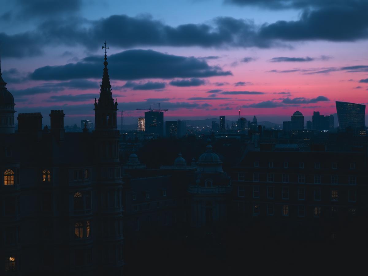 Historic university spires against the London skyline at dusk